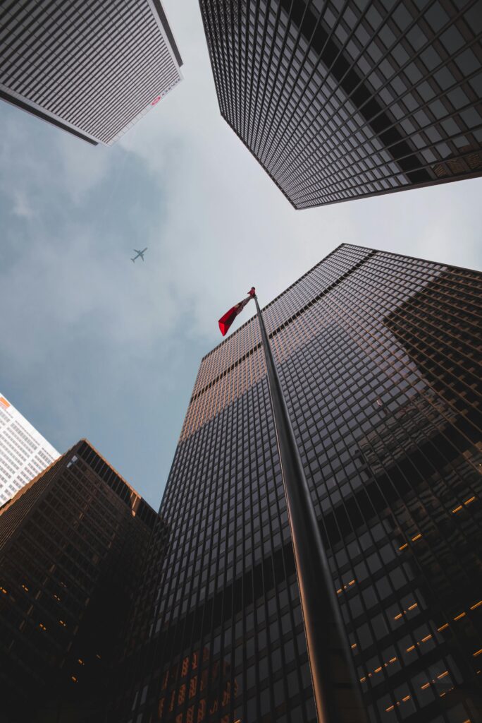 Low angle of modern skyscrapers with a Canadian flag in downtown Toronto.