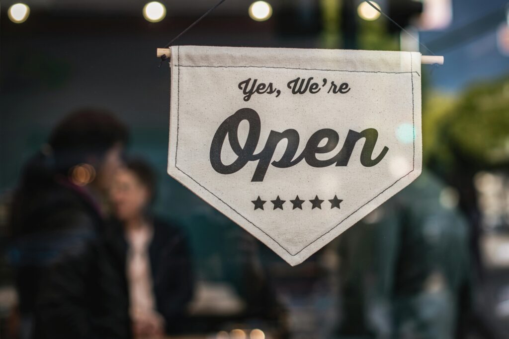 Open sign in a shop window, representing the licensed businesses that licence and permit bonds cover