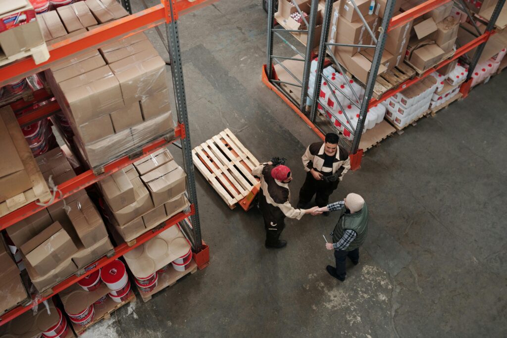 Warehouse workers shaking hands over a completed shipment