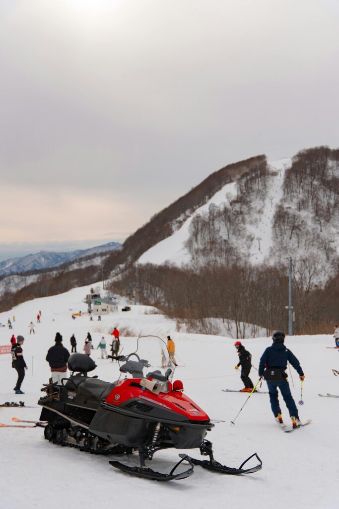 Skiers enjoy the slopes with a snowmobile in Yuzawa, Japan. Perfect winter adventure.