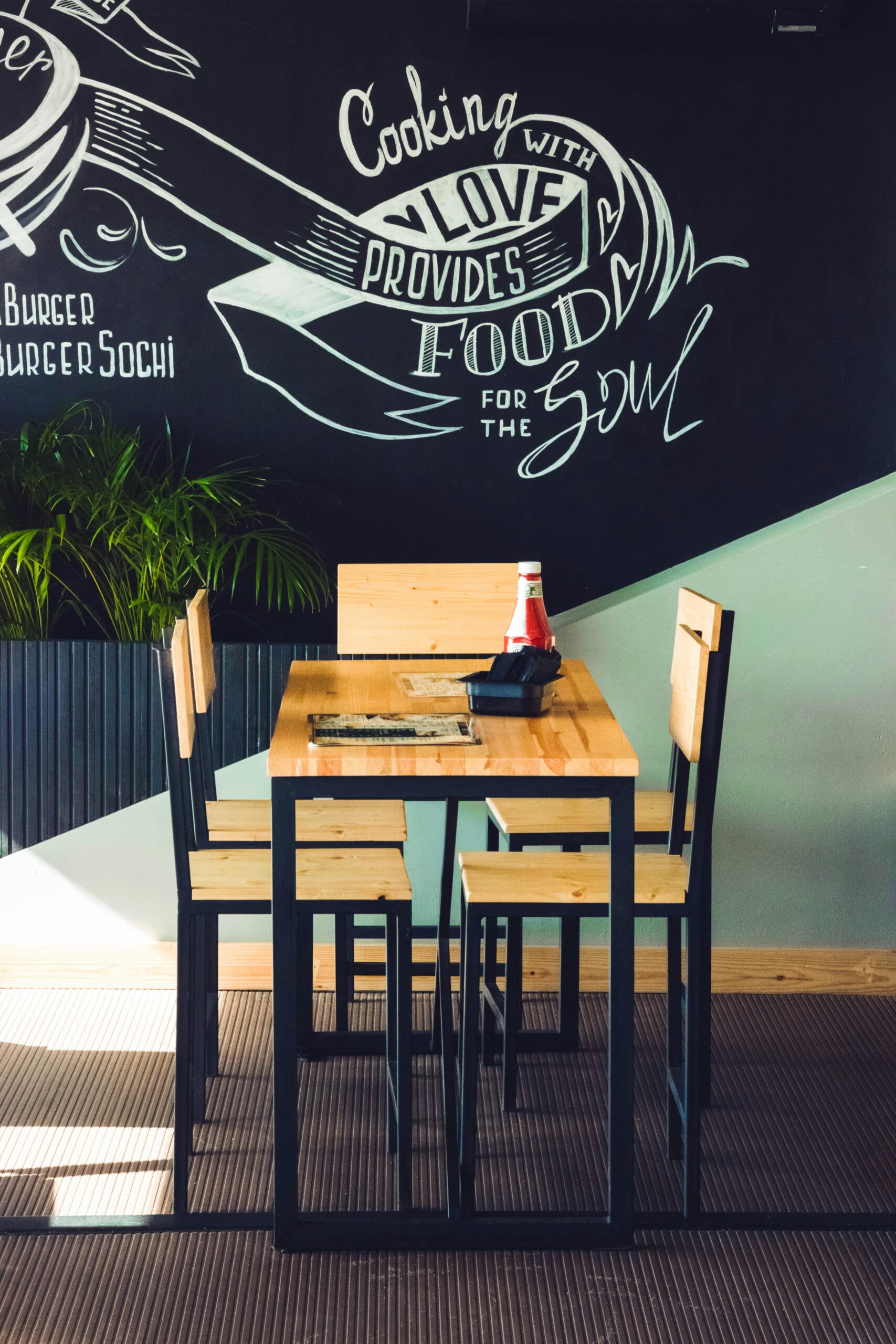 Inviting café interior with wooden chairs and artistic wall design.