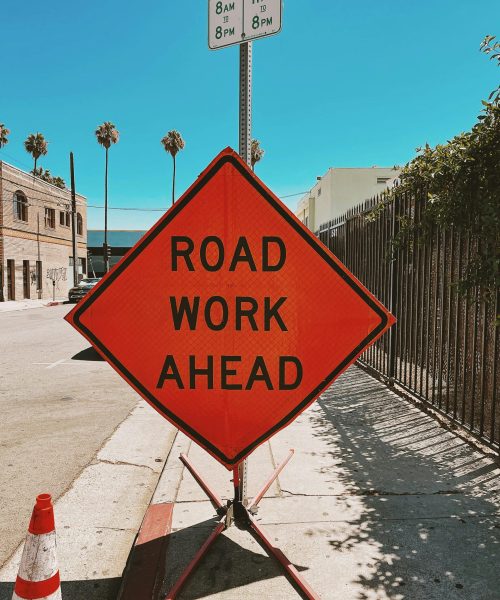 Clear and vibrant road work sign on a sunny Los Angeles street, ensuring safety and awareness.