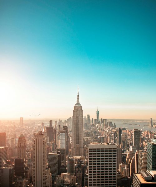 Breathtaking view of New York City's skyline featuring the iconic Empire State Building at sunrise.