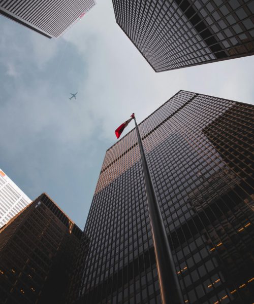 Low angle of modern skyscrapers with a Canadian flag in downtown Toronto.
