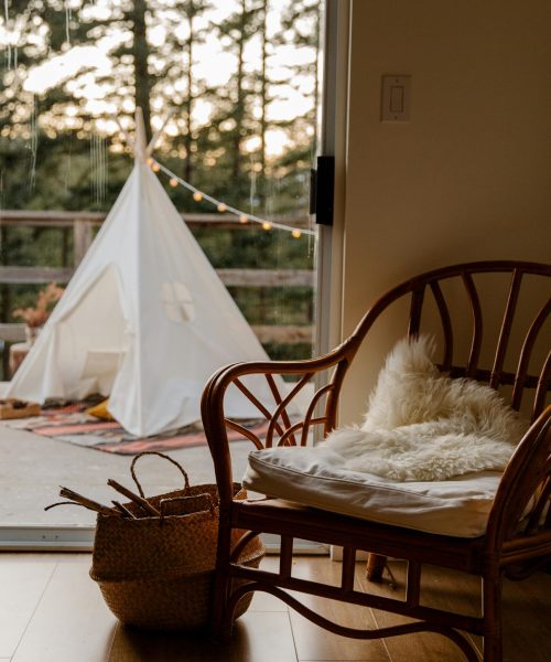 Warm, cozy indoor room leading to a serene outdoor setting with a tent.