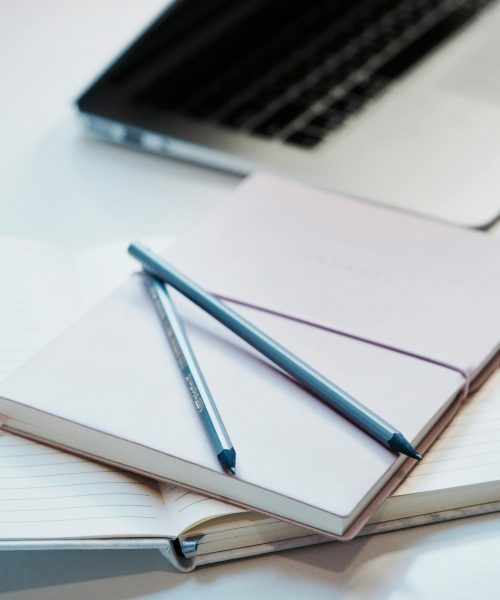 A tidy workspace with notebooks, pencils, and a laptop for productivity.